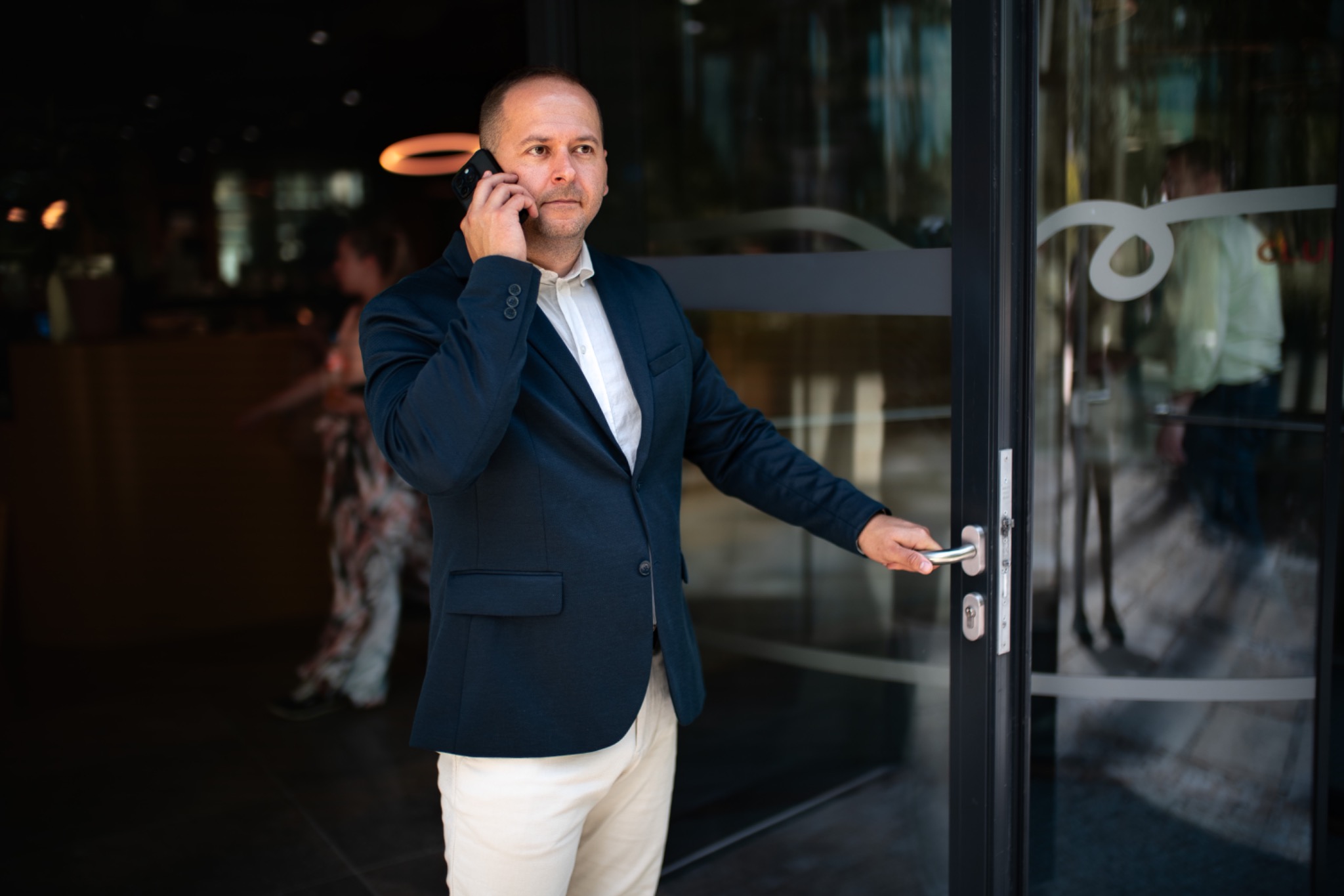 David Katzmair při telefonování u skleněných dveří
